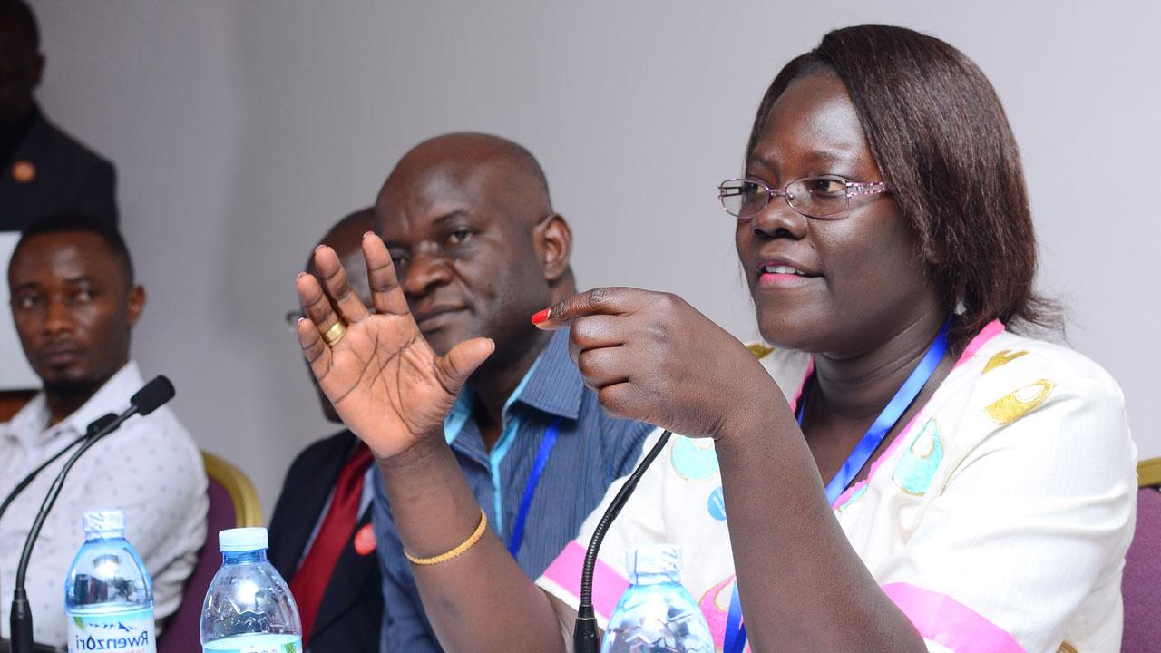 Female doctor speaks to others sitting at a conference table